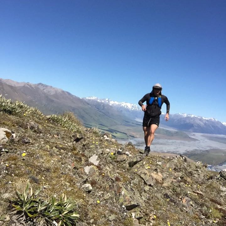 Rob mountain running with snow capped mountains in the background