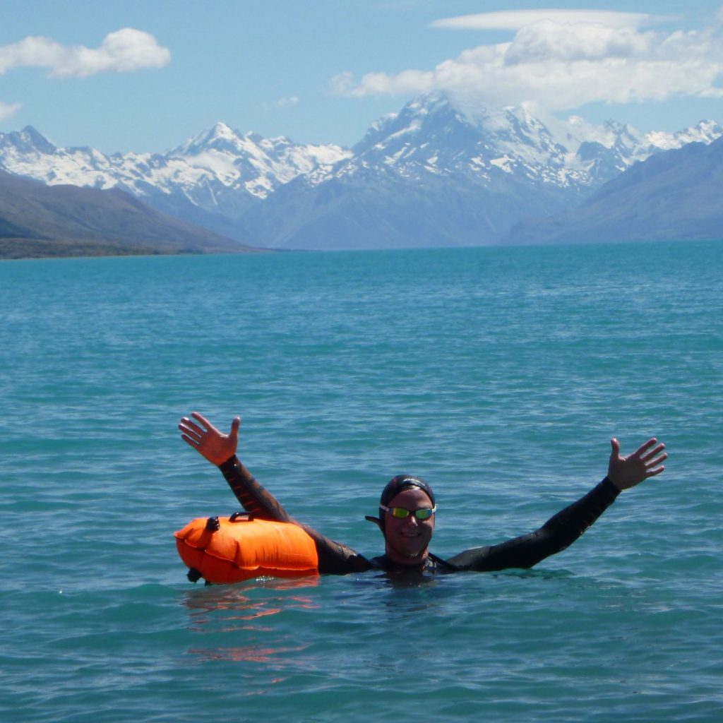 Rob Hutchings swimming in Lake Pukaki with Mt Cook in the back ground