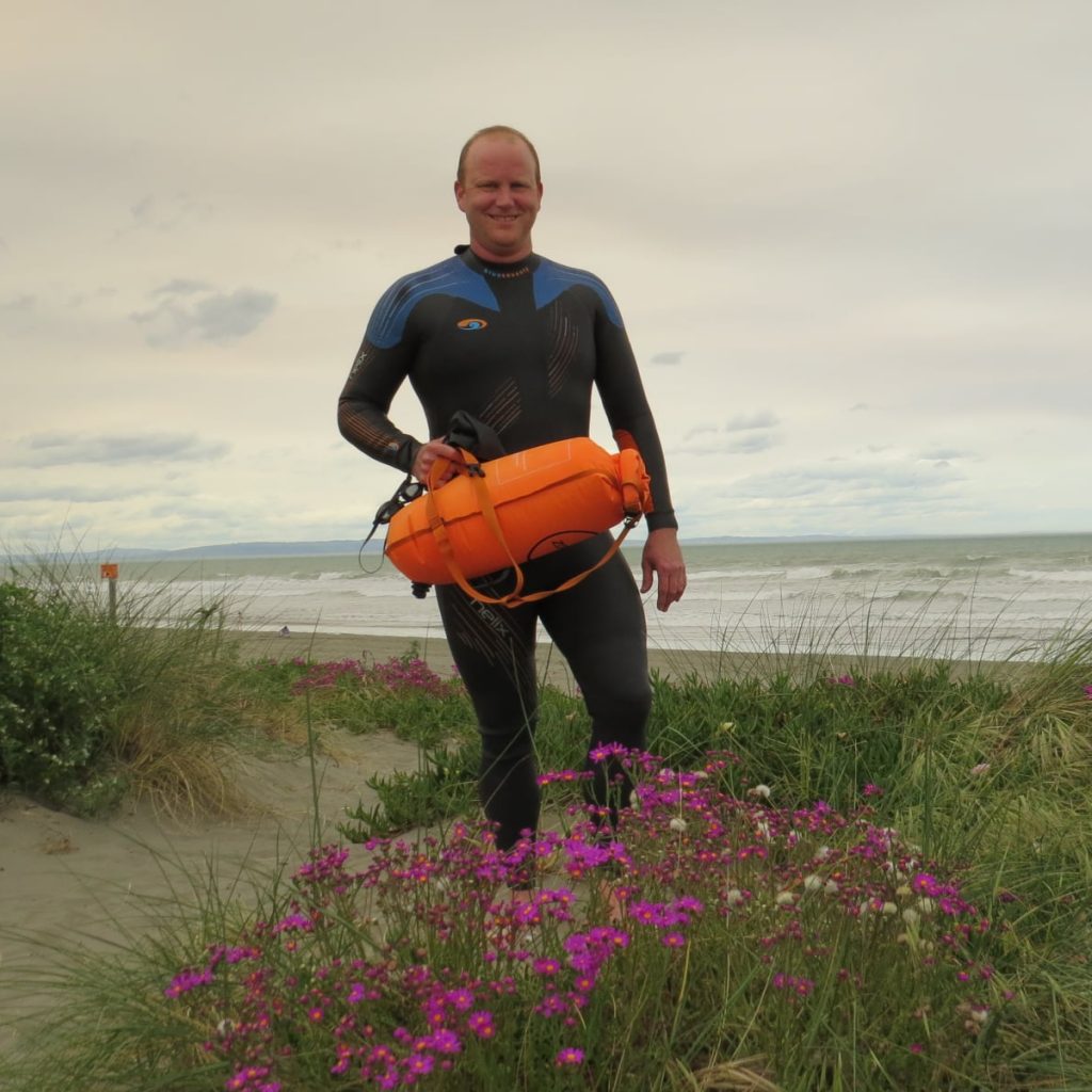 Rob Hutchings holding a safety swim buoy at the beach